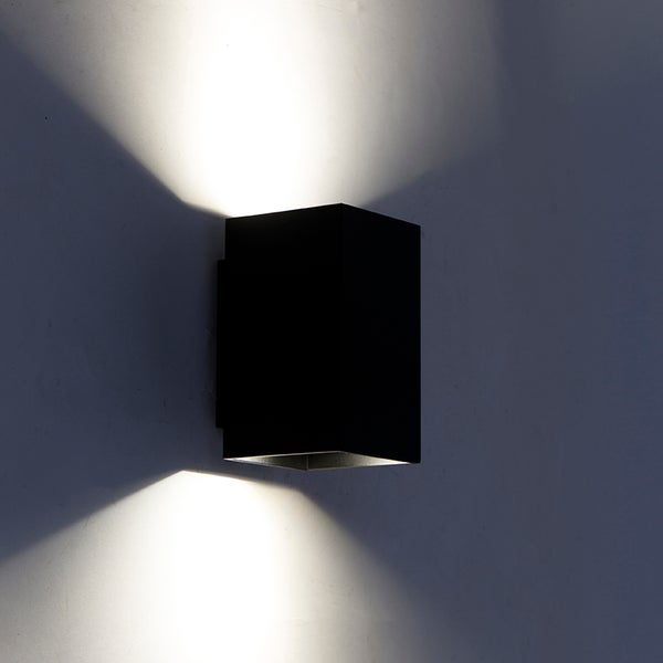 Schwarze, würfelförmige Wandleuchte mit Lichtstrahlen