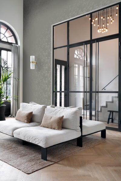 Wohnzimmer mit Sofa, Teppich, Tapete, Lampe und Glastür