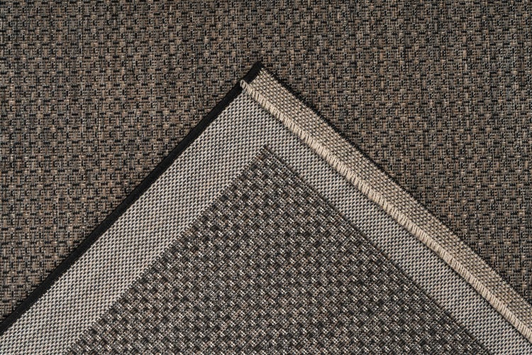 Detailansicht eines gewebten Teppichs mit Oberseite, Unterseite und Randabschluss.