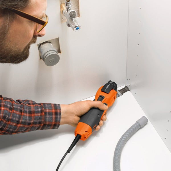 Mann schneidet Ecke mit oszillierender Multifunktionssäge