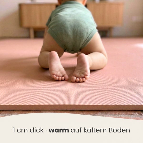 Ein Baby krabbelt auf einer 1 Zentimeter dicken Spielmatte aus Schaumstoff, die Wärme auf kaltem Boden bietet.