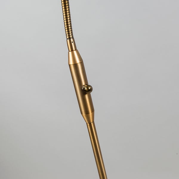 Detailaufnahme einer goldenen Stehlampe mit flexiblem Arm und Schalter