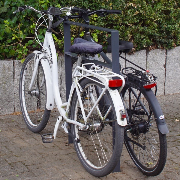 Zwei Fahrräder, abgestellt in einem Fahrradständer.