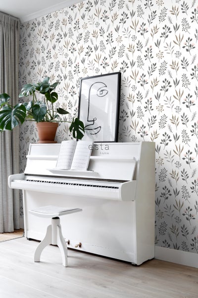 Wohnraum mit weißem Klavier, Hocker, Zimmerpflanze und floraler Tapete