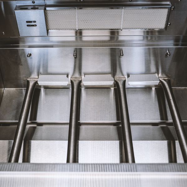 Innenansicht eines Gasgrills mit vier Edelstahl-Stabbrennern und einem Infrarot-Keramik-Heckbrenner.