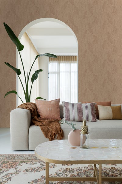 Wohnzimmer mit gemusterter Tapete, Sofa, Kissen und Couchtisch