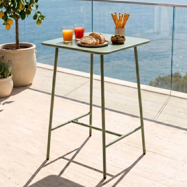 Quadratischer Stehtisch aus Metall auf einem hellen Balkon mit Meerblick, gedeckt mit Getränken und Snacks.