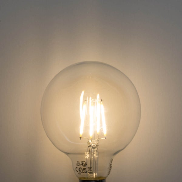 Eingeschaltete LED-Filament-Globelampe aus Klarglas mit sichtbaren Leuchtfäden und CE Kennzeichnung.