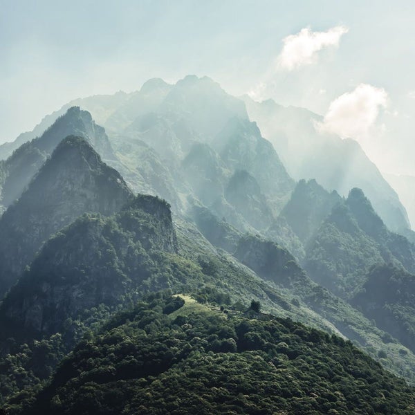 Berge mit Bewaldung unter einem bewölkten Himmel