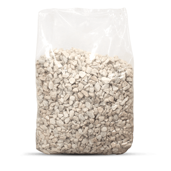 Heller Ziersplitt in einem transparenten Sack für die Gartengestaltung.