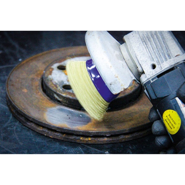 Drahtbürstenaufsatz an Schleifmaschine beim Reinigen einer Metallscheibe