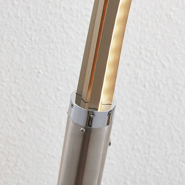 Detail einer Stehlampe aus gebürstetem Metall mit integrierter Beleuchtung.