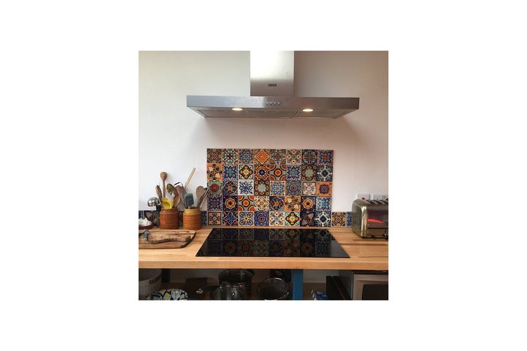 Küchenszene mit Fliesenspiegel im marokkanischen Stil hinter dem Kochfeld.