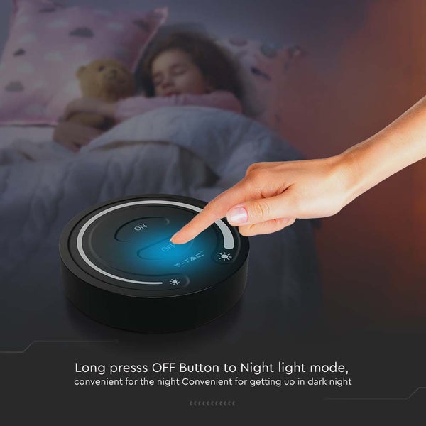 Szene mit Nachttischlampe und einer Hand, die den Schalter betätigt, im Hintergrund ein schlafendes Kind.