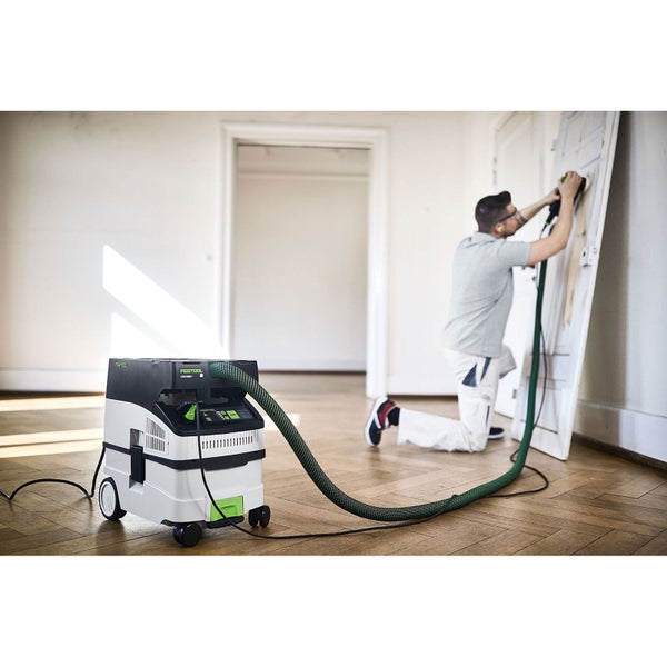 Festool Absaugmobil CTM MIDI I im Einsatz beim Schleifen einer Holztür auf Parkettboden in einem hellen Raum.
