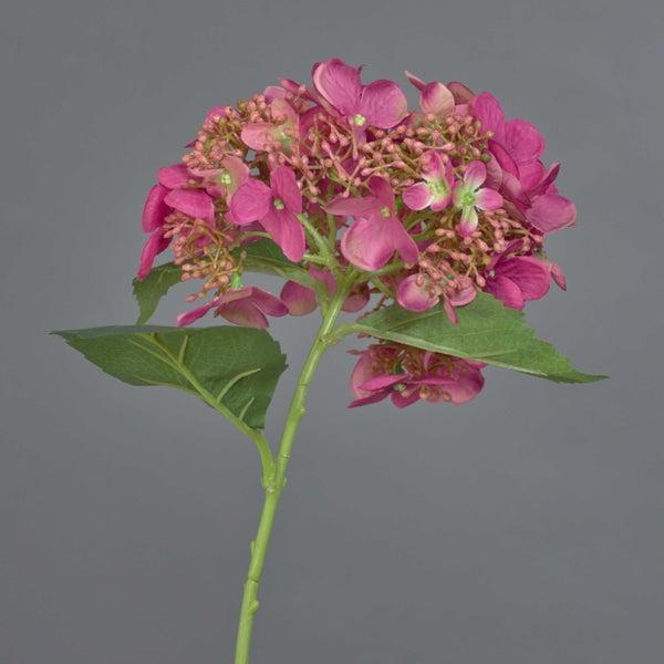 Künstliche Blume mit gelber Knospe und grünen Blättern am Stiel.