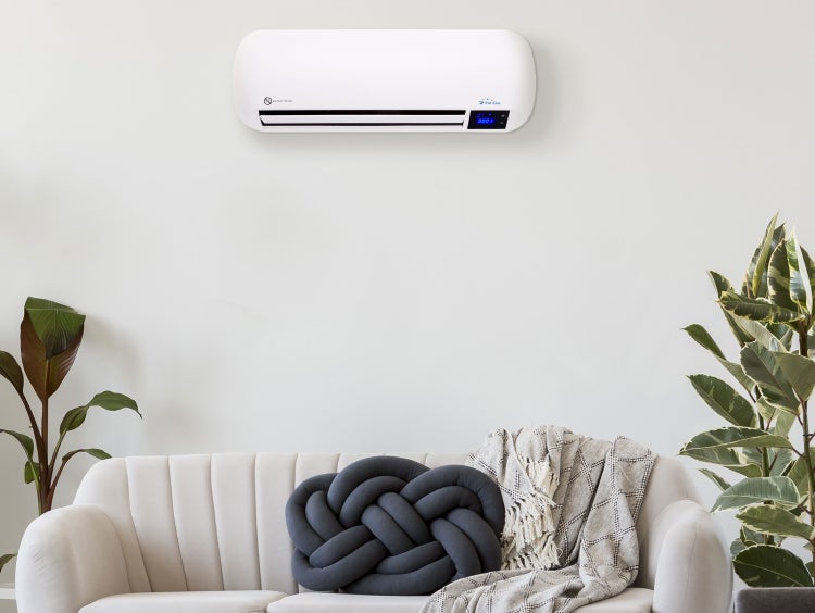 Wohnzimmer mit einem Pur Line Heizlüfter an der Wand über einem Sofa