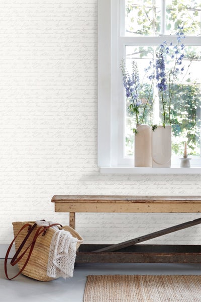 Heller Raum mit floral gemusterter Tapete, Holzbank und Dekoration