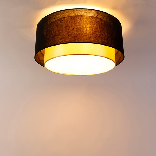 Runde Deckenleuchte mit zweilagigem Textilschirm in Schwarz und Gold sowie weißem Diffusor.