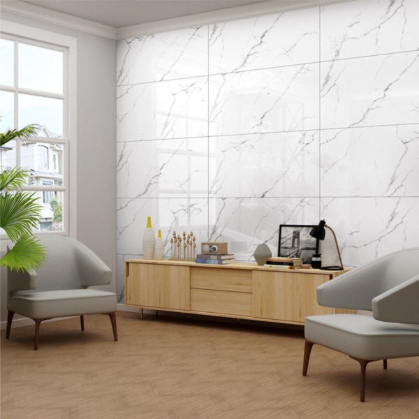 Wohnzimmer mit Fliesen in Marmoroptik an der Wand, Holzfußboden und hellen Möbeln.