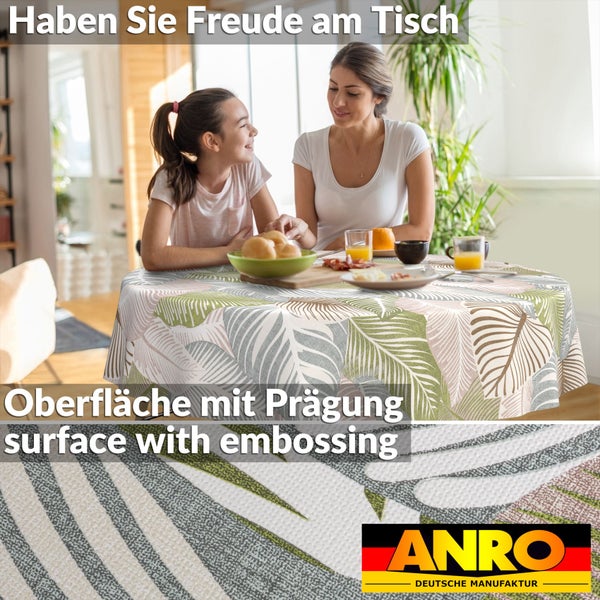 Runde Tischdecke mit Palmenblattmuster und geprägter Oberfläche in einem hellen Esszimmer mit Personen am Tisch. ANRO Logo.