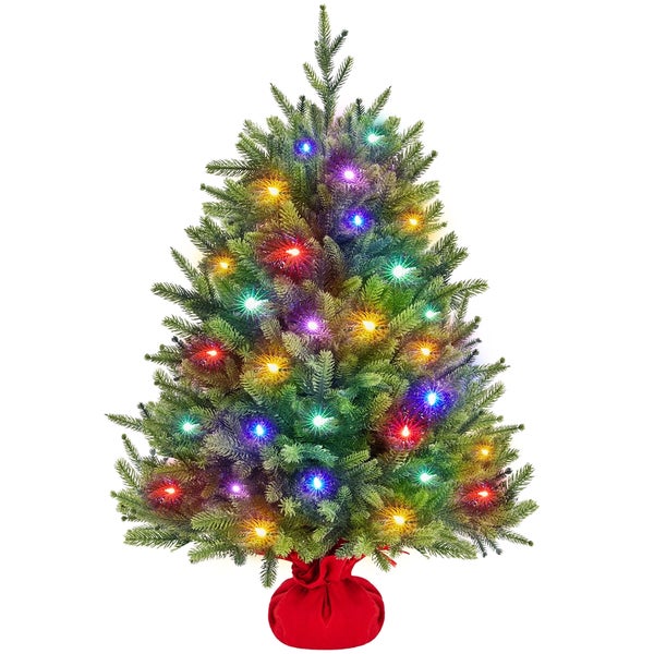 Geschmückter Weihnachtsbaum mit Beleuchtung und rotem Ständer