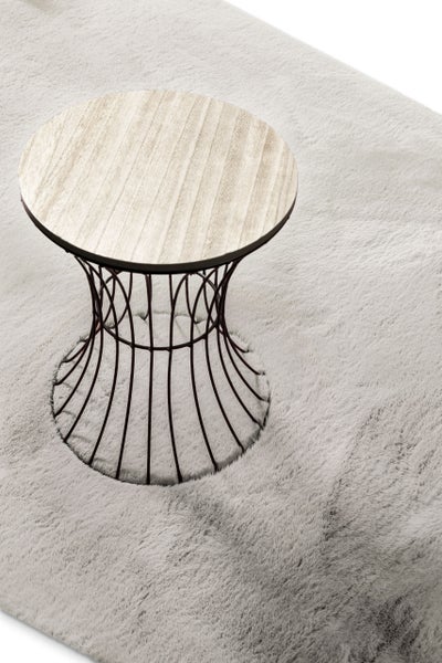 Runder Beistelltisch mit einer Tischplatte in heller Holzoptik und einem dunklen Metallgestell in Sanduhrform auf einem flauschigen Teppich.