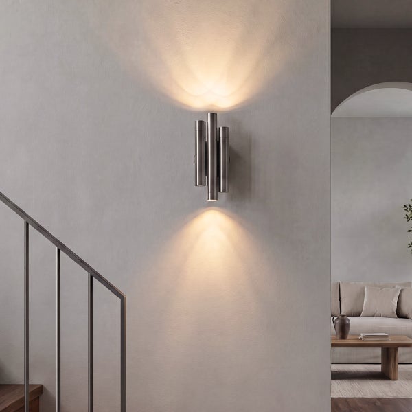 Moderne Wandleuchte in zylindrischer Optik mit indirektem Lichtkegel nach oben und unten an einer Wand im Treppenbereich montiert