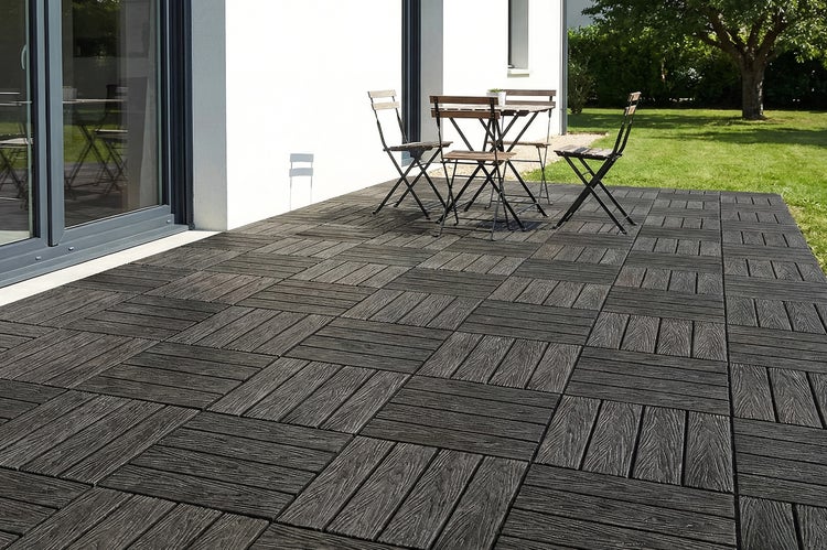 Moderne Terrassenfliesen in Holzoptik verlegt auf einer Terrasse vor einem Wohnhaus mit Gartenmöbeln und großer Glasfront