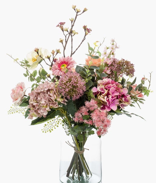 Künstlicher Blumenstrauß mit Rosen, Hortensien und Dekozweigen in einer Glasvase.
