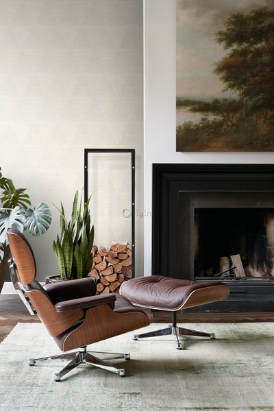 Wohnzimmer mit Sessel, Ottomane, Kamin und Holzlager