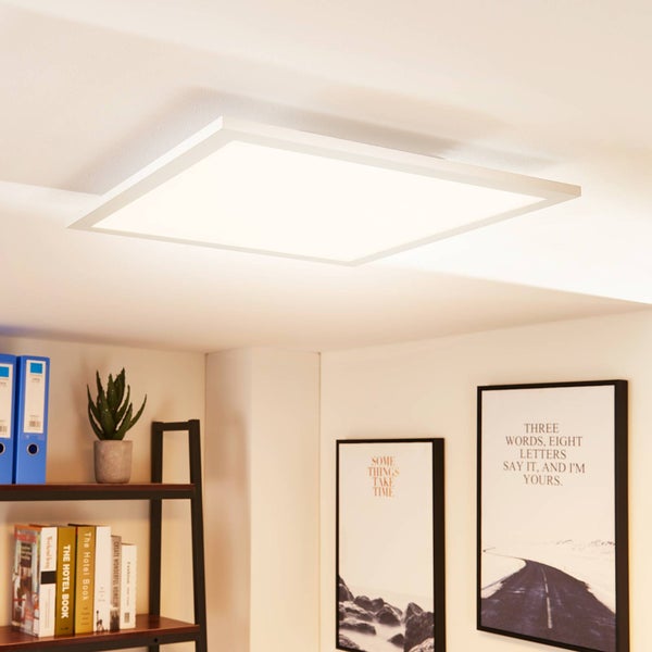 Quadratisches LED-Panel als Deckenleuchte in einem hellen, organisierten Arbeitszimmer über einem Regal und Wandbildern.