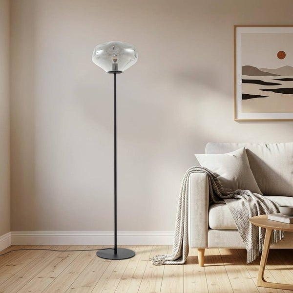 Stehleuchte mit Glasschirm und Metallfuß neben Sofa im Wohnzimmer