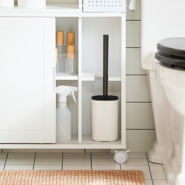 Badezimmer mit weißem Badschrank, Reinigungsflasche und WC-Bürste