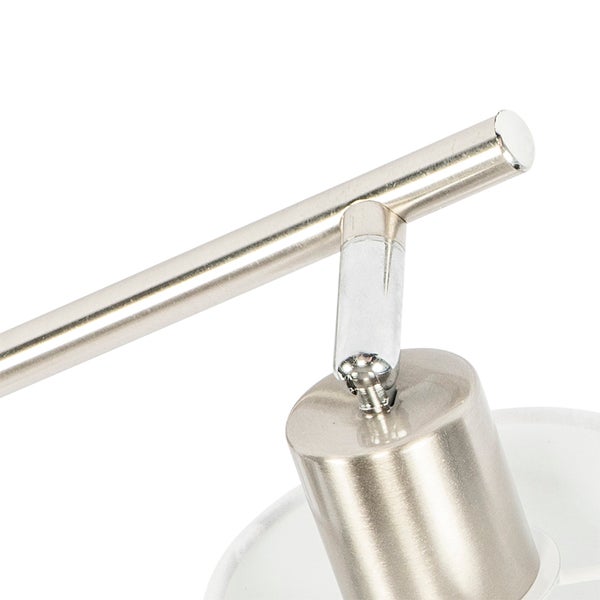 Detailansicht eines Deckenstrahlers aus gebürstetem Metall mit Gelenk und weißem Schirm.