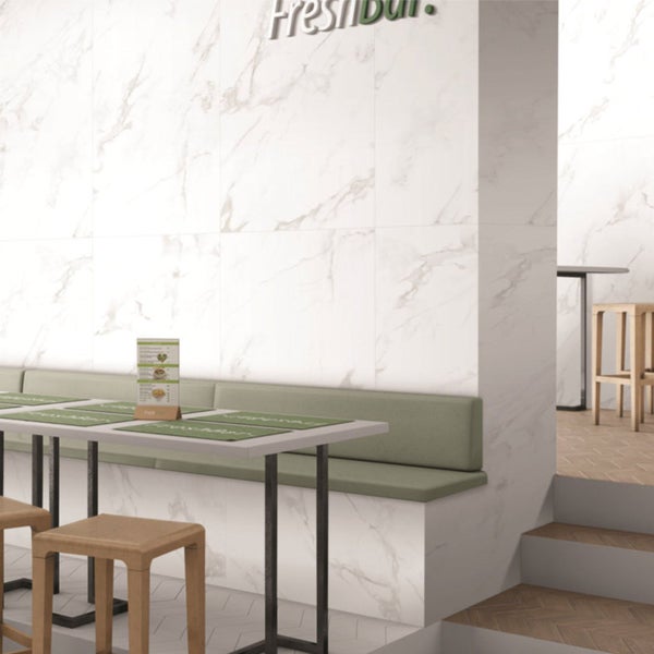 Heller Raum mit Marmorfliesen, Sitzbank und Tischen