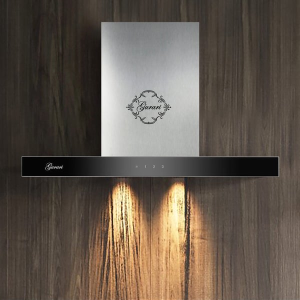 Moderne Gurari Wandhaube aus Edelstahl mit schwarzer Glasfront und integrierter Beleuchtung vor einer holzfarbenen Wand.