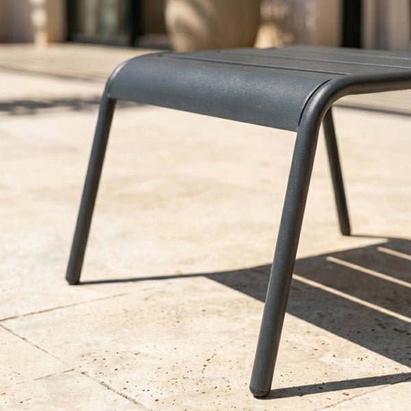 Detailansicht eines Gartenhockers aus Metall in Anthrazit auf einer Terrasse.