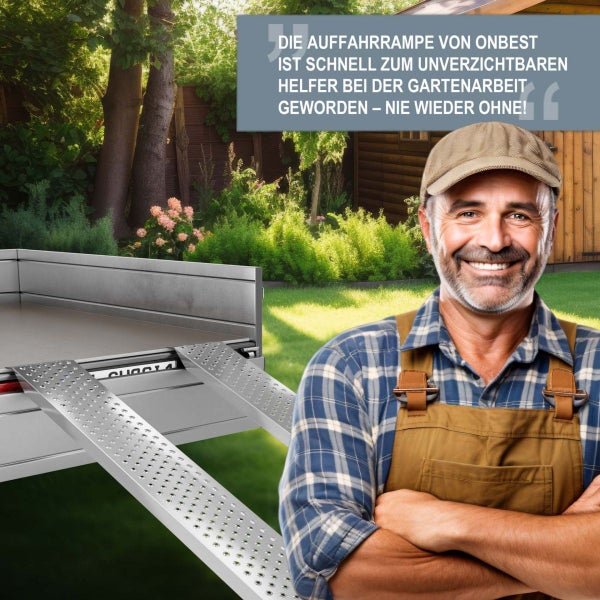 Ein lächelnder Mann in Arbeitskleidung steht neben einer Aluminium-Auffahrrampe an einem Anhänger in einem sonnigen Garten.