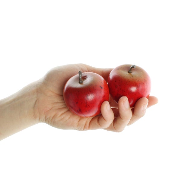 Eine Hand hält zwei künstliche Äpfel