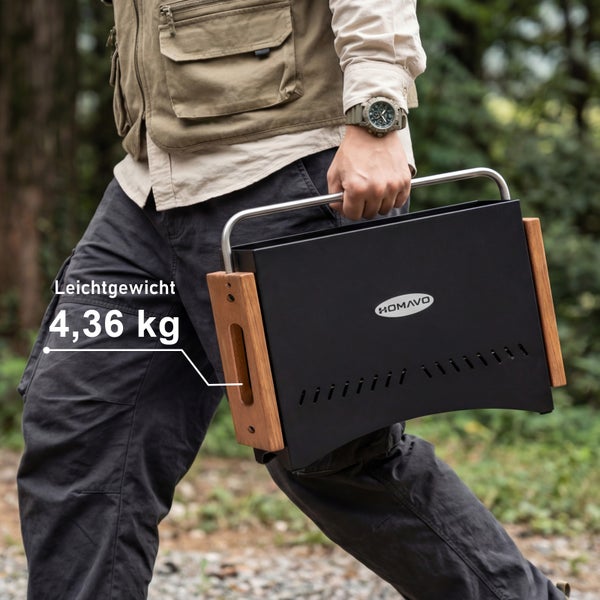 Person trägt einen tragbaren ROMAVO Grill mit Metallgriff und Holzseiten, Gewicht 4,36 Kilogramm, im Freien.