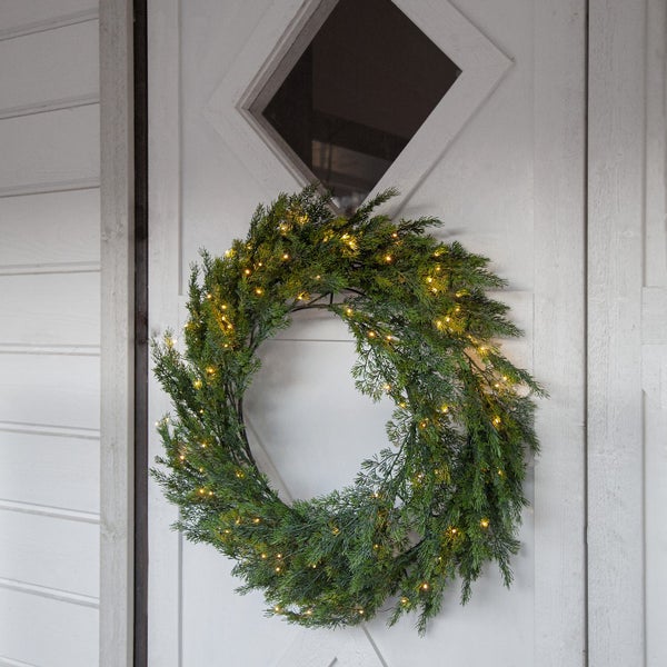 Dekorativer Türkranz mit Beleuchtung an einer weißen Tür