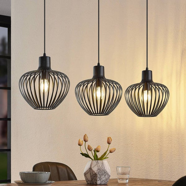 Dreiflammige Pendelleuchte aus schwarzem Metalldraht über einem Esstisch mit eingeschalteten Leuchtmitteln.