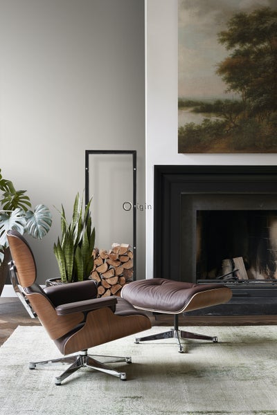 Wohnzimmer-Szene mit Sessel, Fußhocker, Kamin und Dekoration