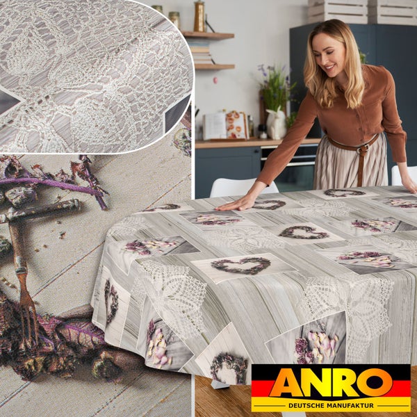 Tischdecke mit Holzoptik, floralen Herzmotiven und Spitzenmuster in einer hellen Küche. ANRO Deutsche Manufaktur Logo.