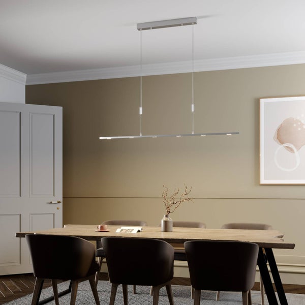 Moderne lineare LED Pendelleuchte aus Metall über einem rustikalen Holztisch in einem minimalistisch eingerichteten Esszimmer.