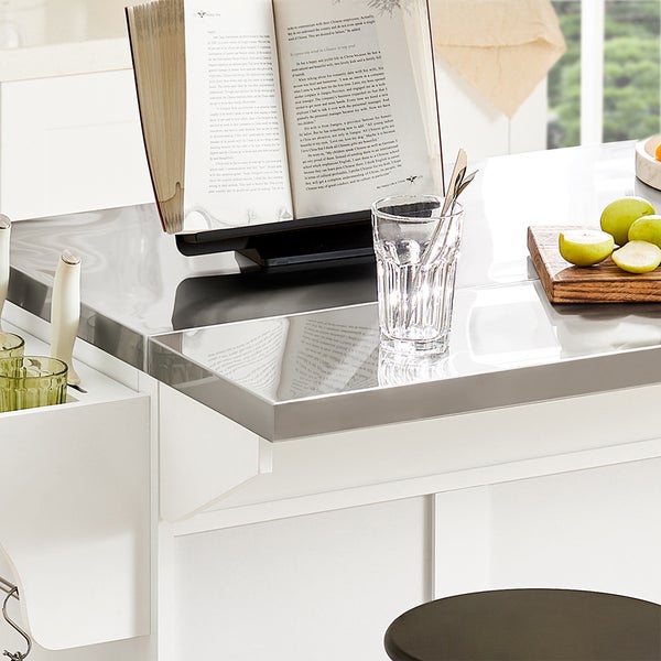 Detailaufnahme einer Küchentheke mit Kochbuch, Glas und Äpfeln