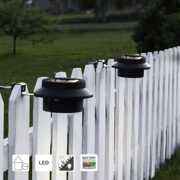 Zwei schwarze LED-Zaunleuchten mit Solarpanel an einem weißen Zaun