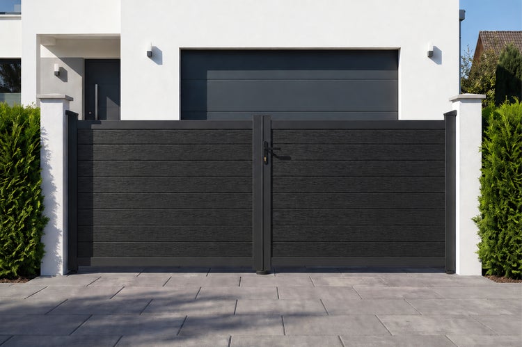 Modernes Doppelflügeltor mit horizontalen Lamellen in Holzoptik und anthrazitfarbenem Metallrahmen vor einer Garageneinfahrt.