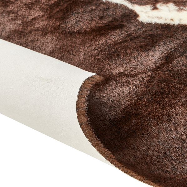 Detailansicht eines Kunstfell-Teppichs in Kuhfell-Optik mit weichem Flor und glatter Unterseite